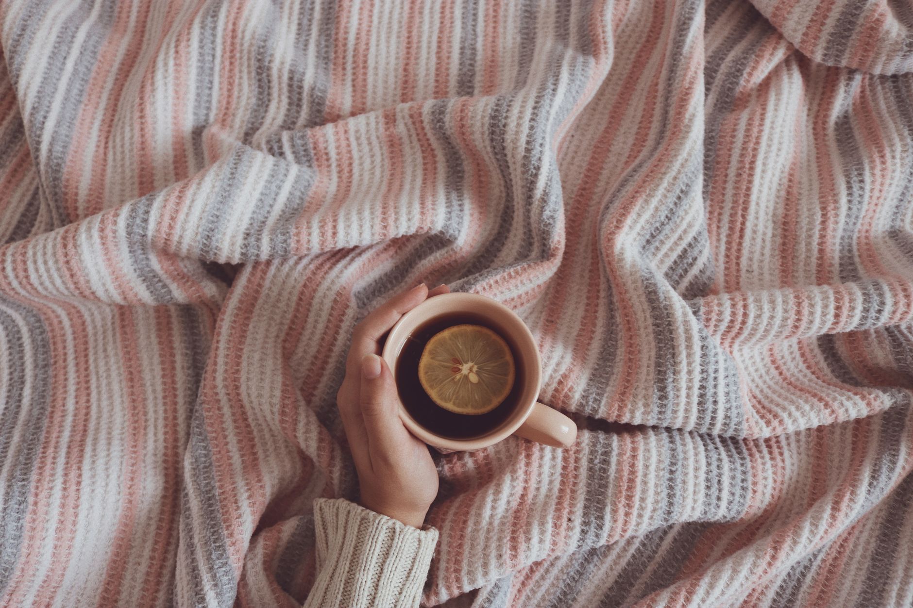 Genesungswünsche per WhatsApp – wärmende Tasse Tee auf einer Decke