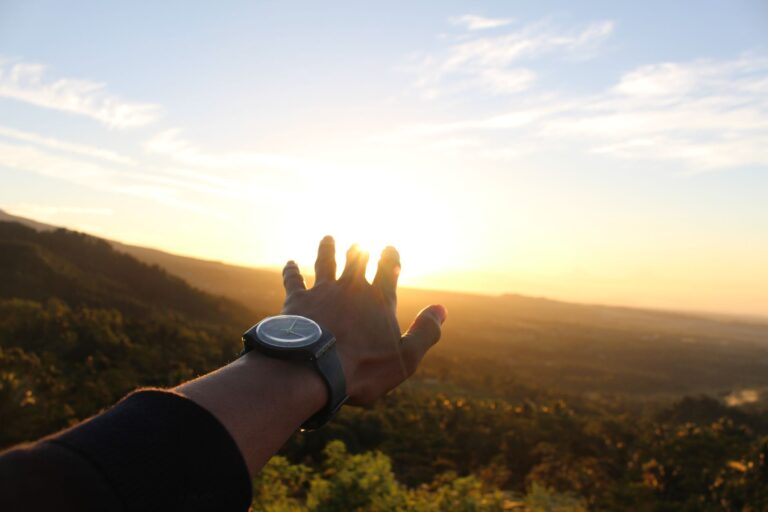 Kraft und Genesungswünsche – eine Hand öffnet sich dem Sonnenaufgang entgegen