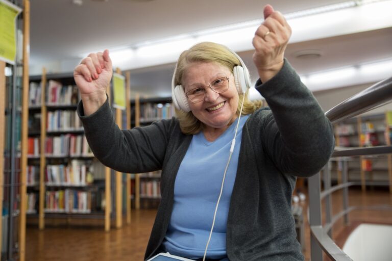 Musik im Alter: Warum Singen und Hören guttun Musik im Alter – fröhliche Seniorin tanzt mit Kopfhörern zur Musik