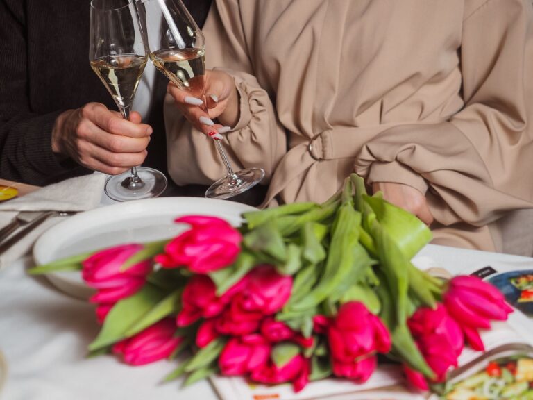 Ruhestand Glückwünsche und Zitate – Anstoßen mit Sekt über einem Tulpenstrauß